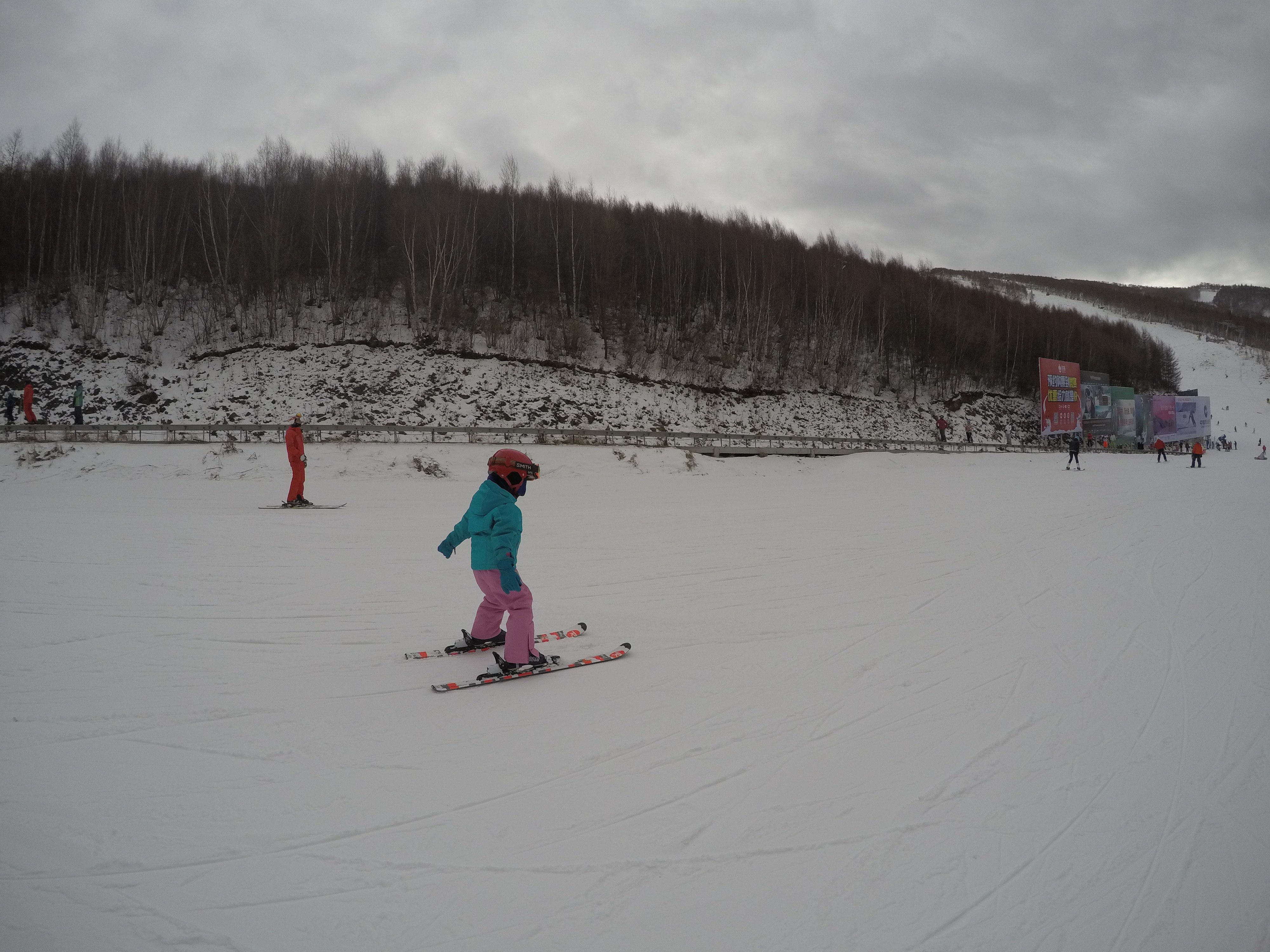 年幼的我穿着蓝色滑雪服在初级雪道上滑行
