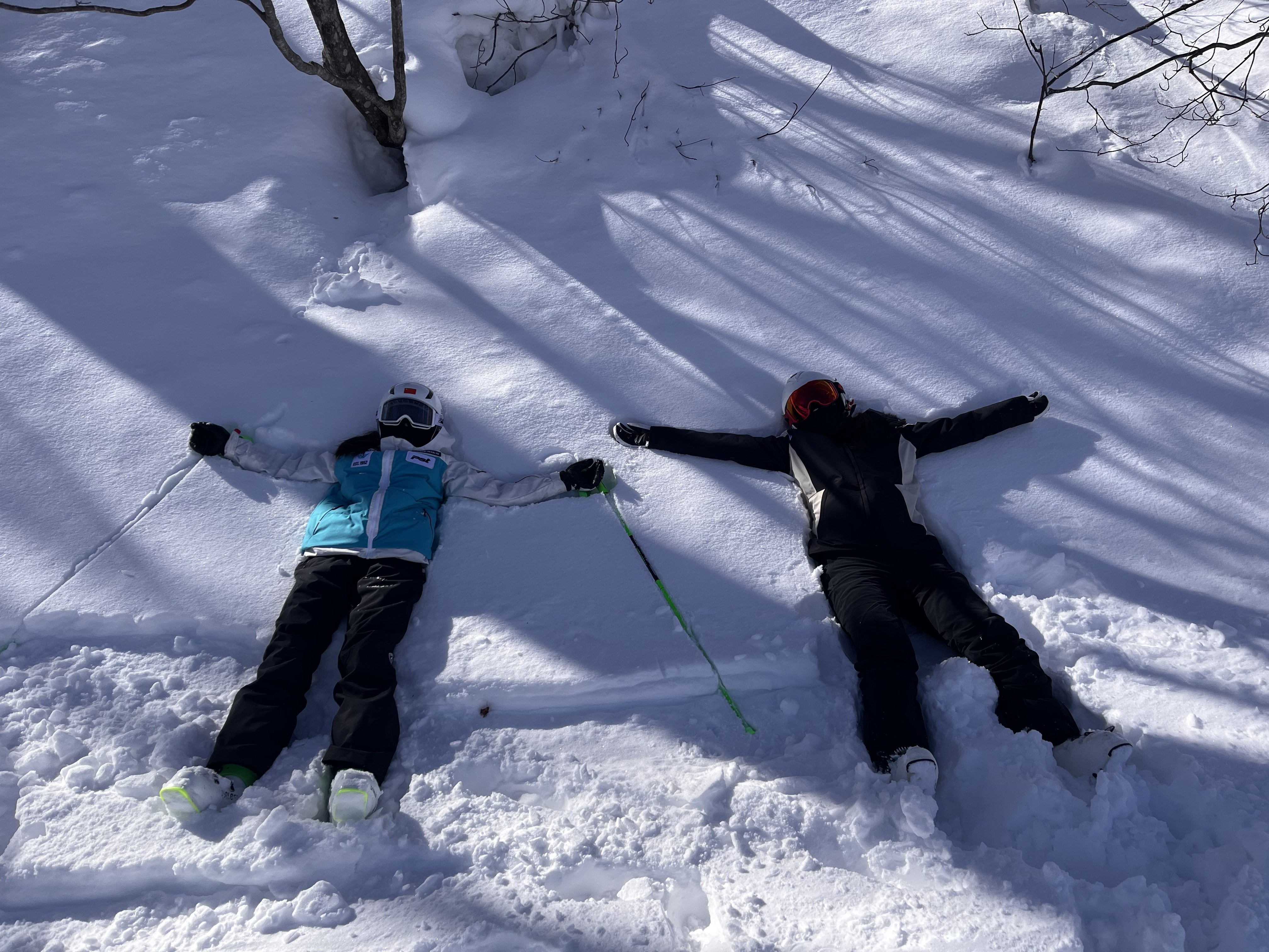 我和家人并肩躺在树林间松软的天然积雪上